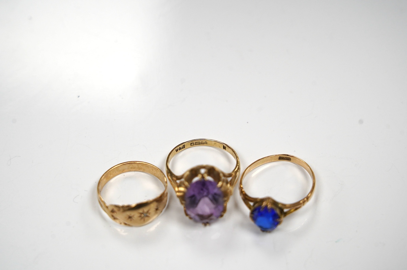 A modern 9ct gold and amethyst set dress ring, a 9ct and diamond chip set ring and a yellow metal (stamped 15c) and blue stone set ring, gross weight 8.2 grams. Condition - poor to fair